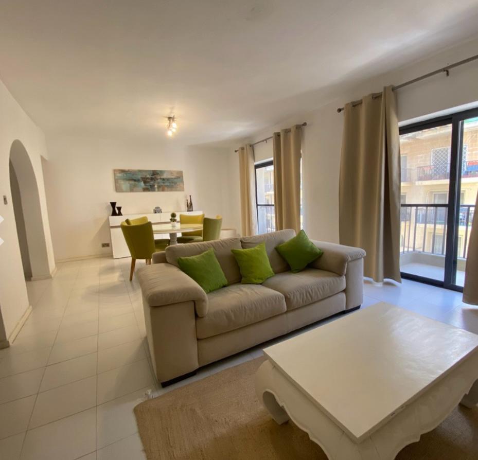 Sala de convivência com sofá e varanda da acomodação em Malta